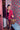 Woman holding a rolling suitcase in one hand and a cheetah print handle bag in the other